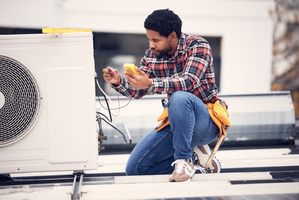 Air conditioner, roof and technician man repair, maintenance and working on electrical power genera